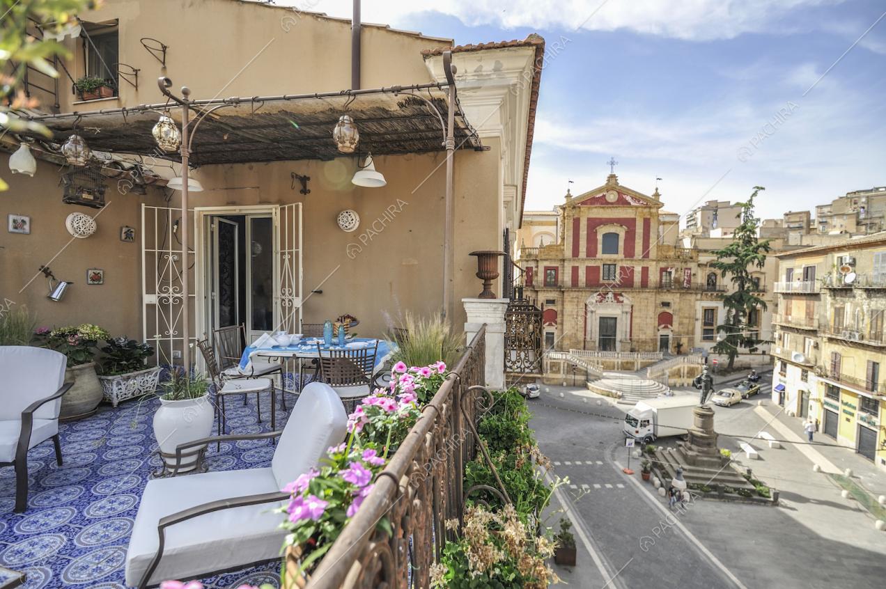 Terrazza con tavolo, sedie in ferro, piccolo bersò e ringhiera in ferro