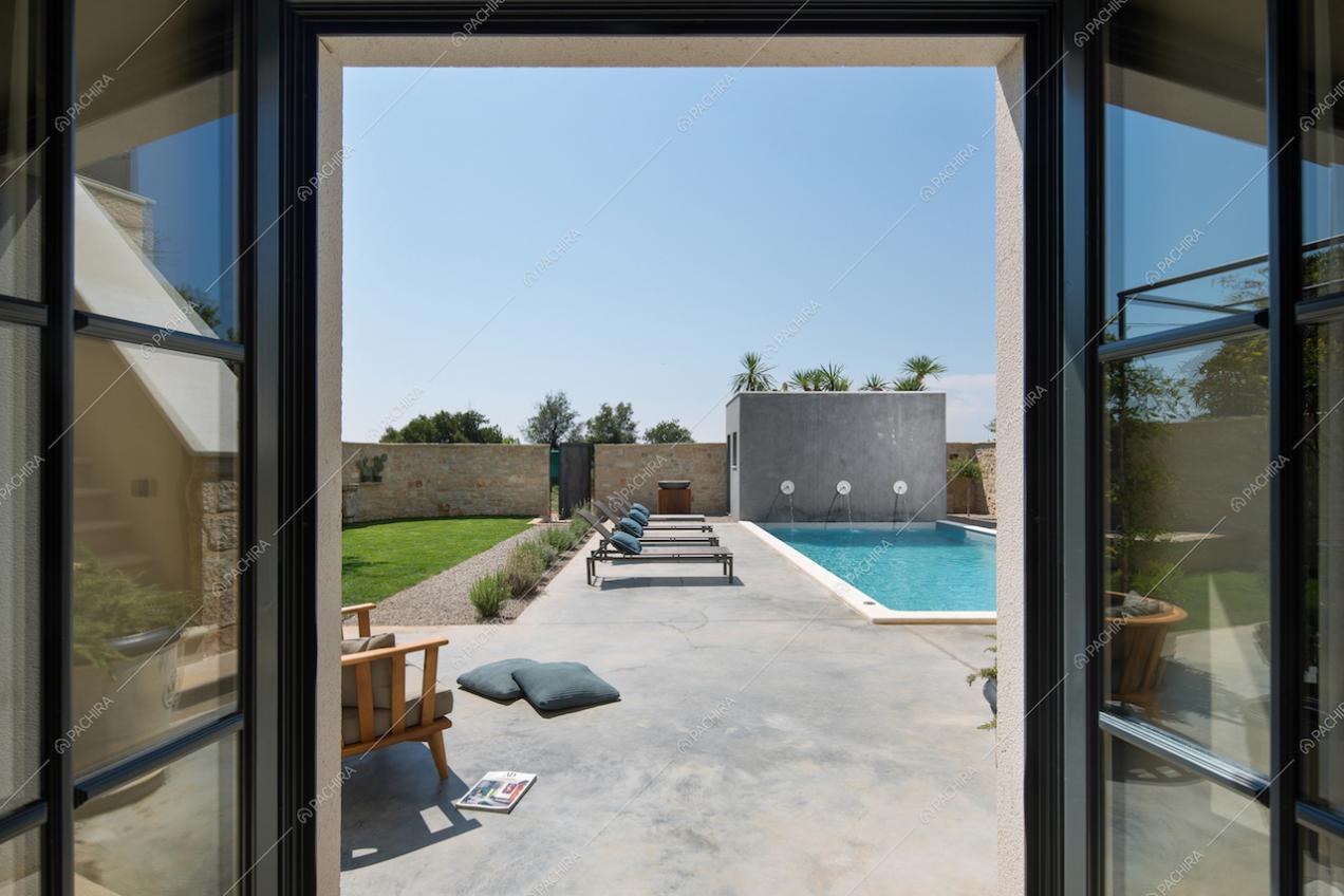 Vista sulla piscina esterna e le mura di recinzione