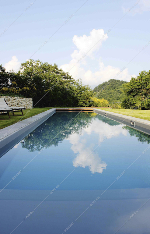 La grande piscina all'aperto immersa nel verde