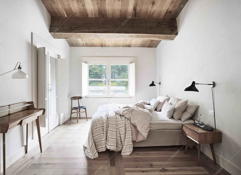 La camera da letto con pavimento in parquet di questa villa dai colori tenui