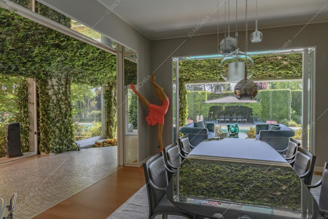 Splendida veranda con sala da pranzo, vetrate e vista sui rampicanti sulle mura della villa
