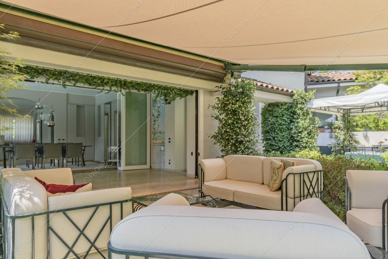 Divani bianchi nel giardino della location riparati da una grande tenda