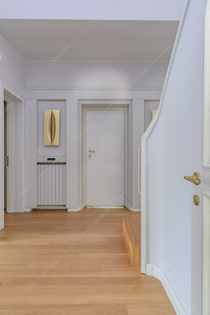 Atrio con pavimento in parquet, pareti bianche e scale