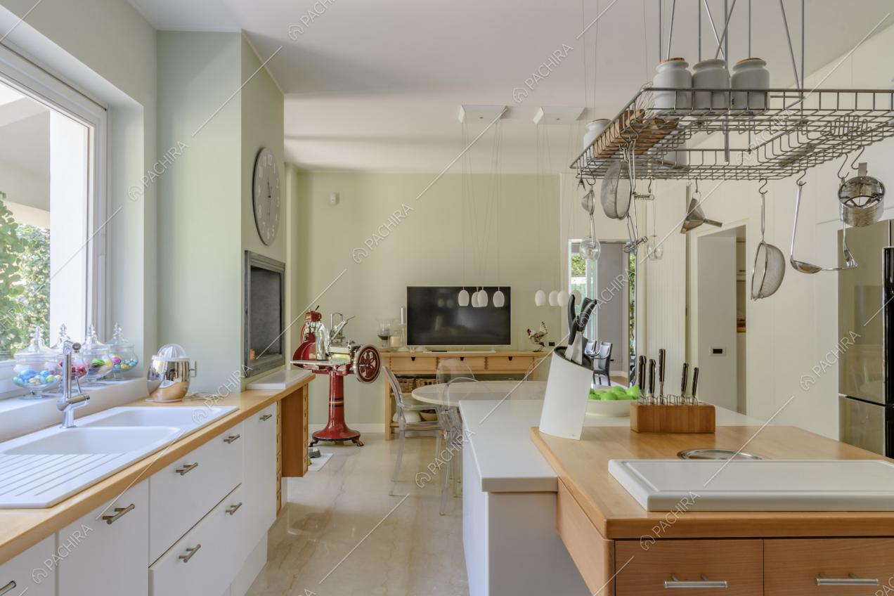 Dall'isola bianca della cucina con tagliere vista sul tavolo da pranzo rotondo