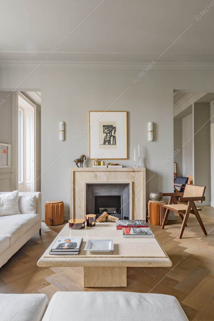 Salotto con pavimento in parquet, divano bianco angolare, tavolino in marmo e camino