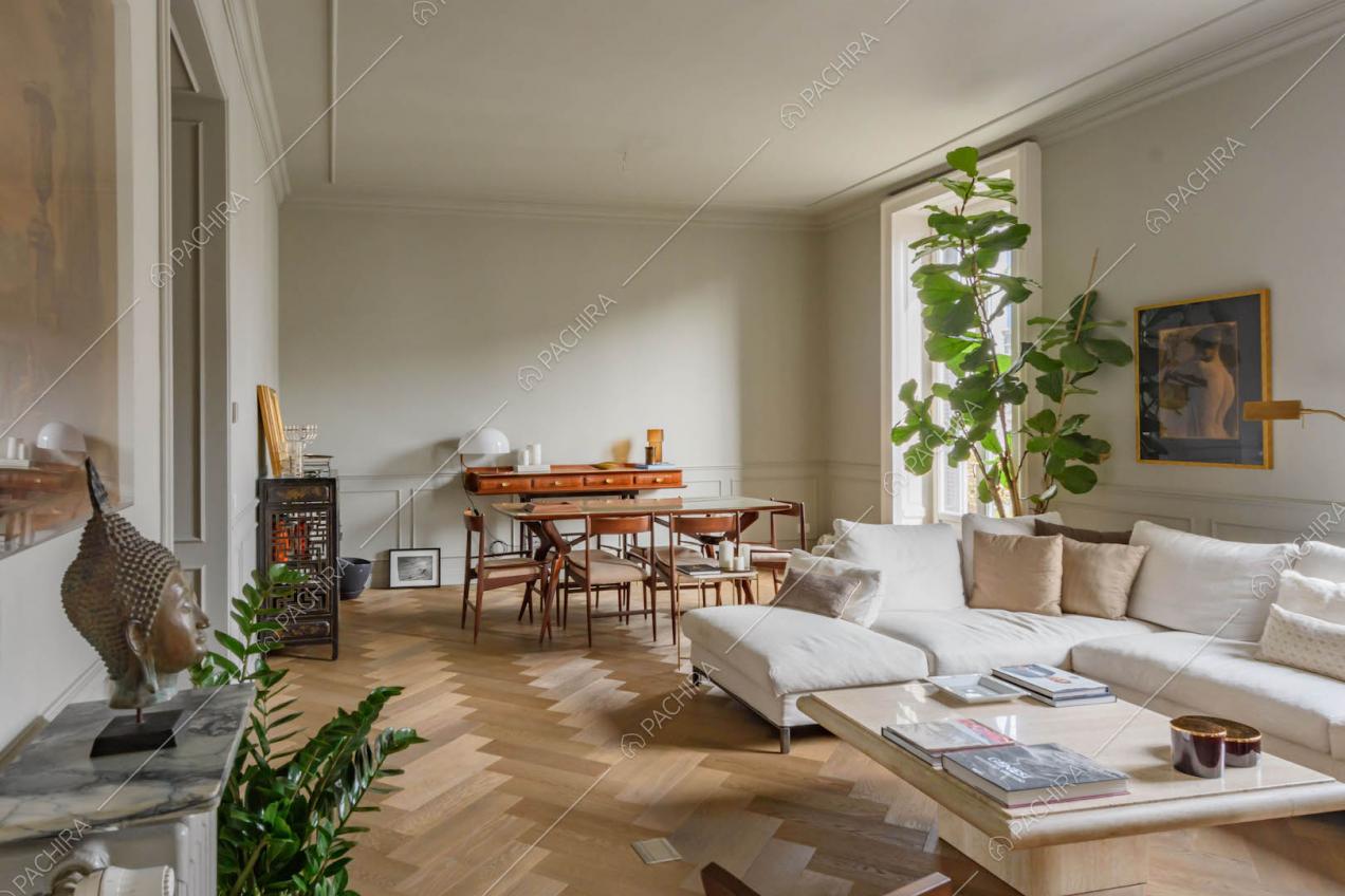 Spazioso salotto con pavimento in parquet a spina di pesce e boiserie alle pareti