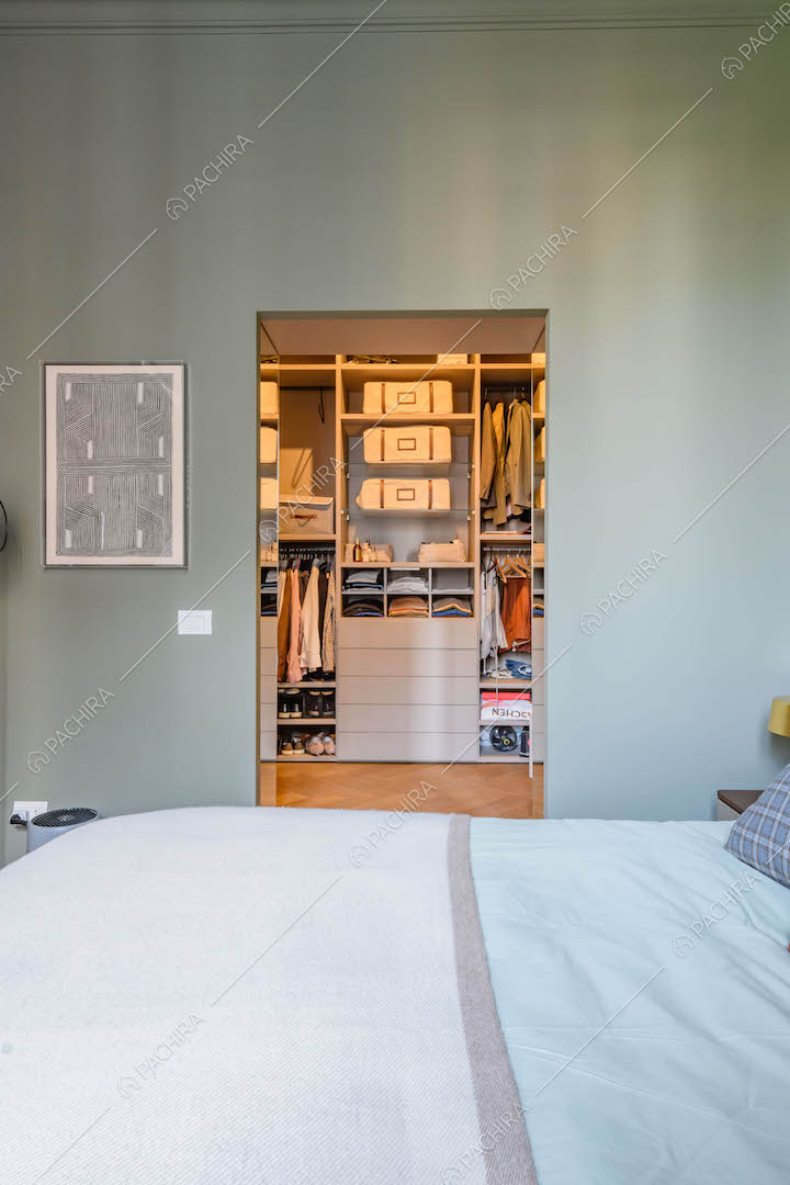 Dal letto matrimoniale della camera con boiserie sul soffitto vista sulla cabina armadio