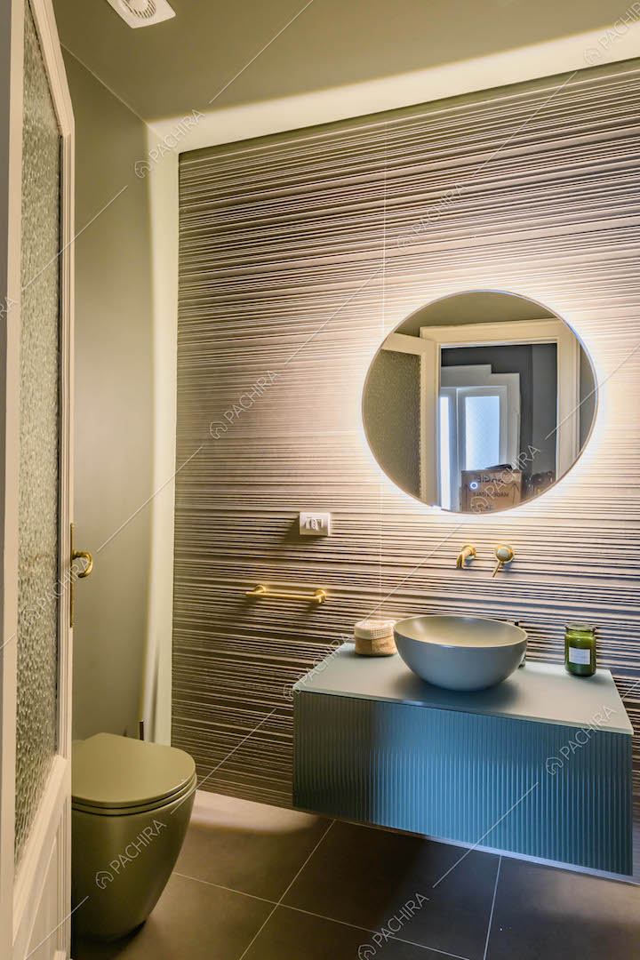 Bagno con specchio retro-illuminato, pavimento nero e pareti verdi