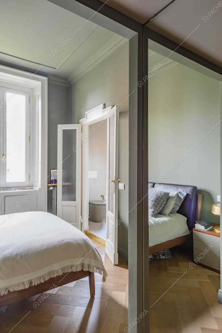 Camera da letto con pavimento in parquet a spina di pesce e colonne