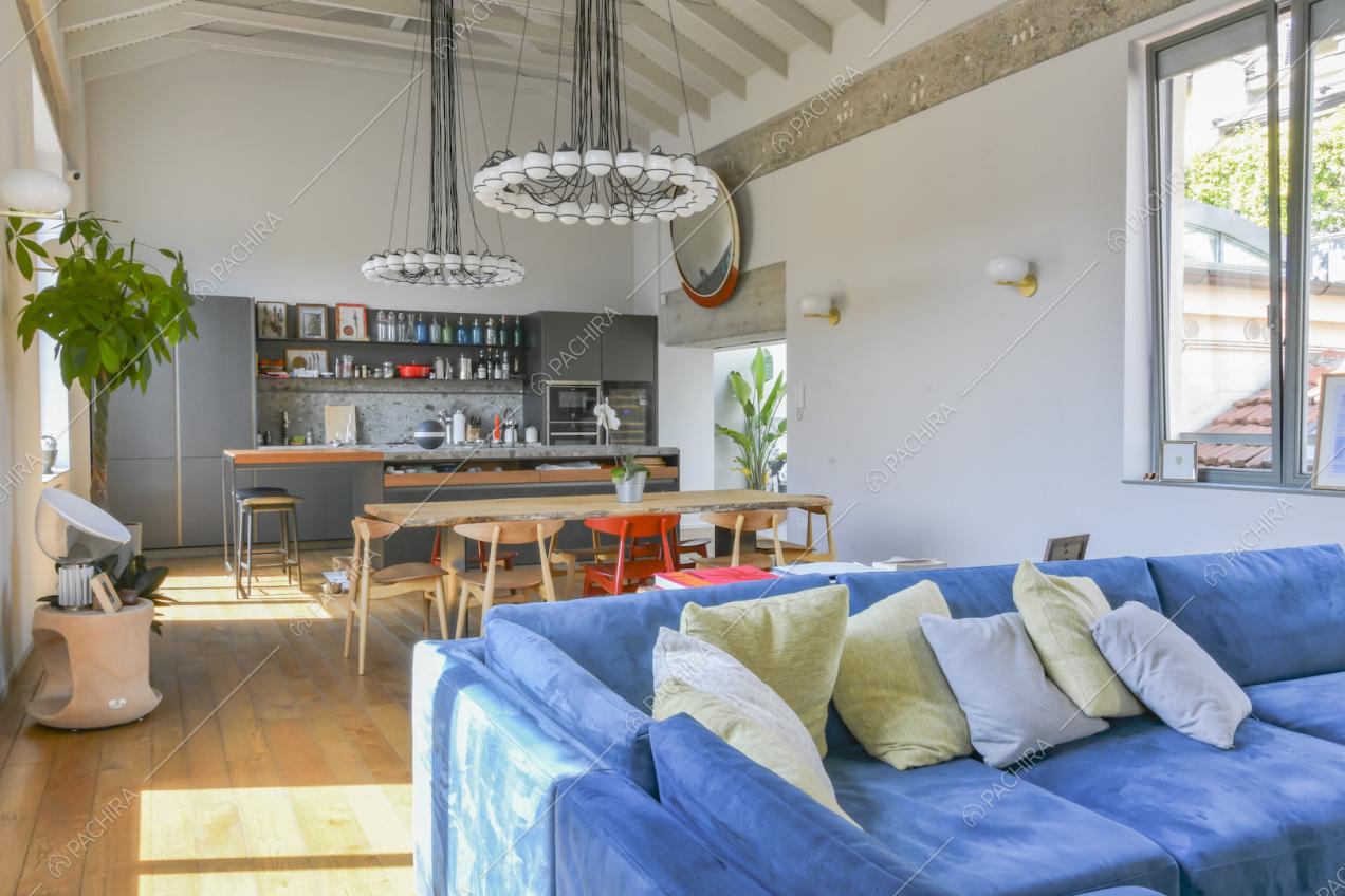 Zona giorno con cucina a parete, tavolo da pranzo e travi a vista