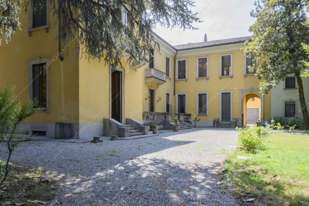 Esterni gialli della dimora storica con pavimentazione in ghiaia