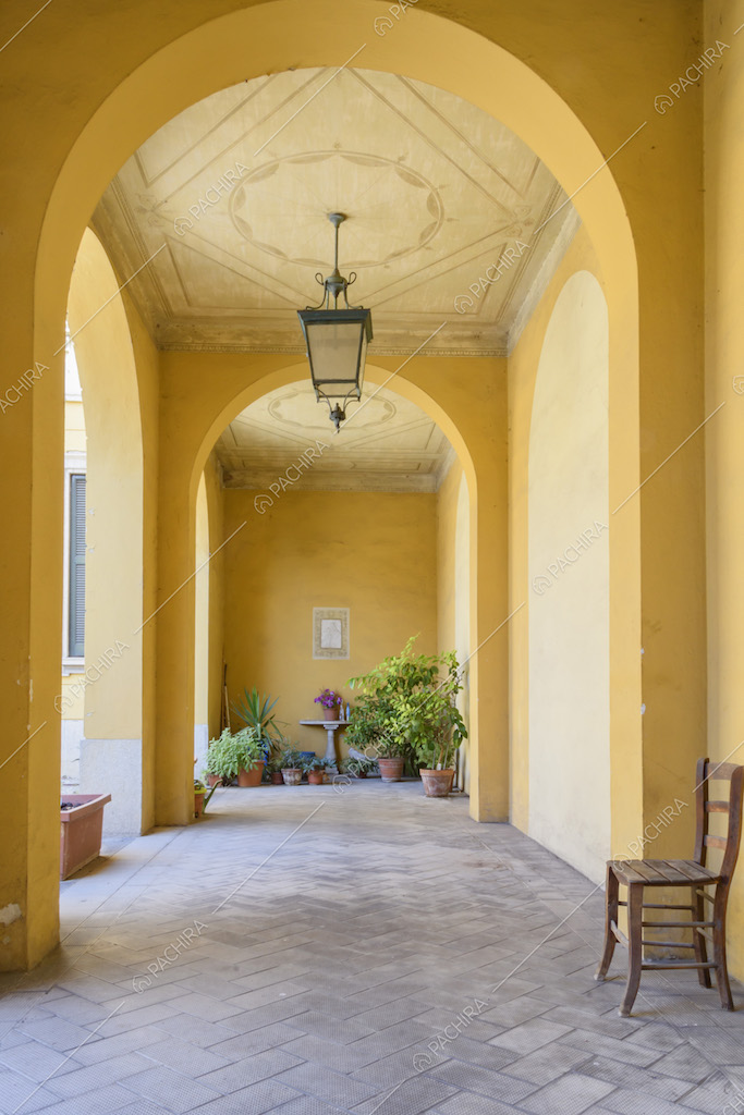 Portico giallo con volte ad arco, boiserie sul soffitto e pavimento a spina di pesce