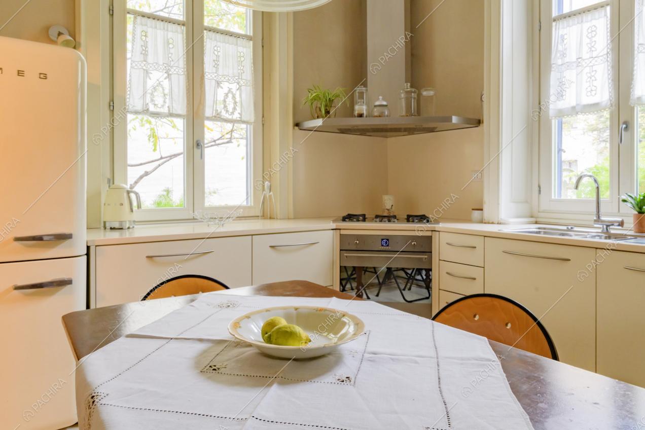 Tavolo da pranzo in legno nella cucina angolare a parete con fornelli a gas