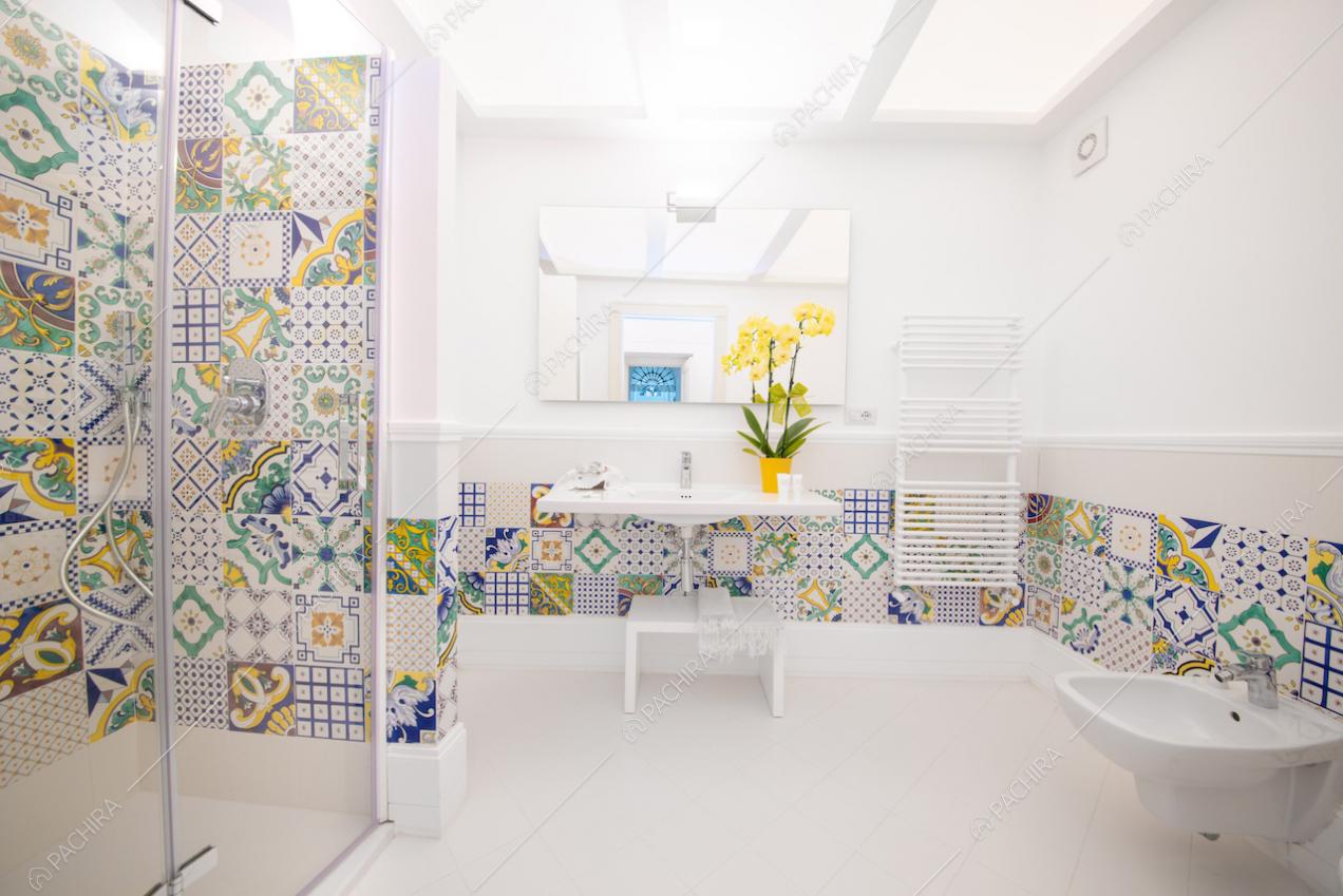 Bagno con arredi bianchi e cementine colorate