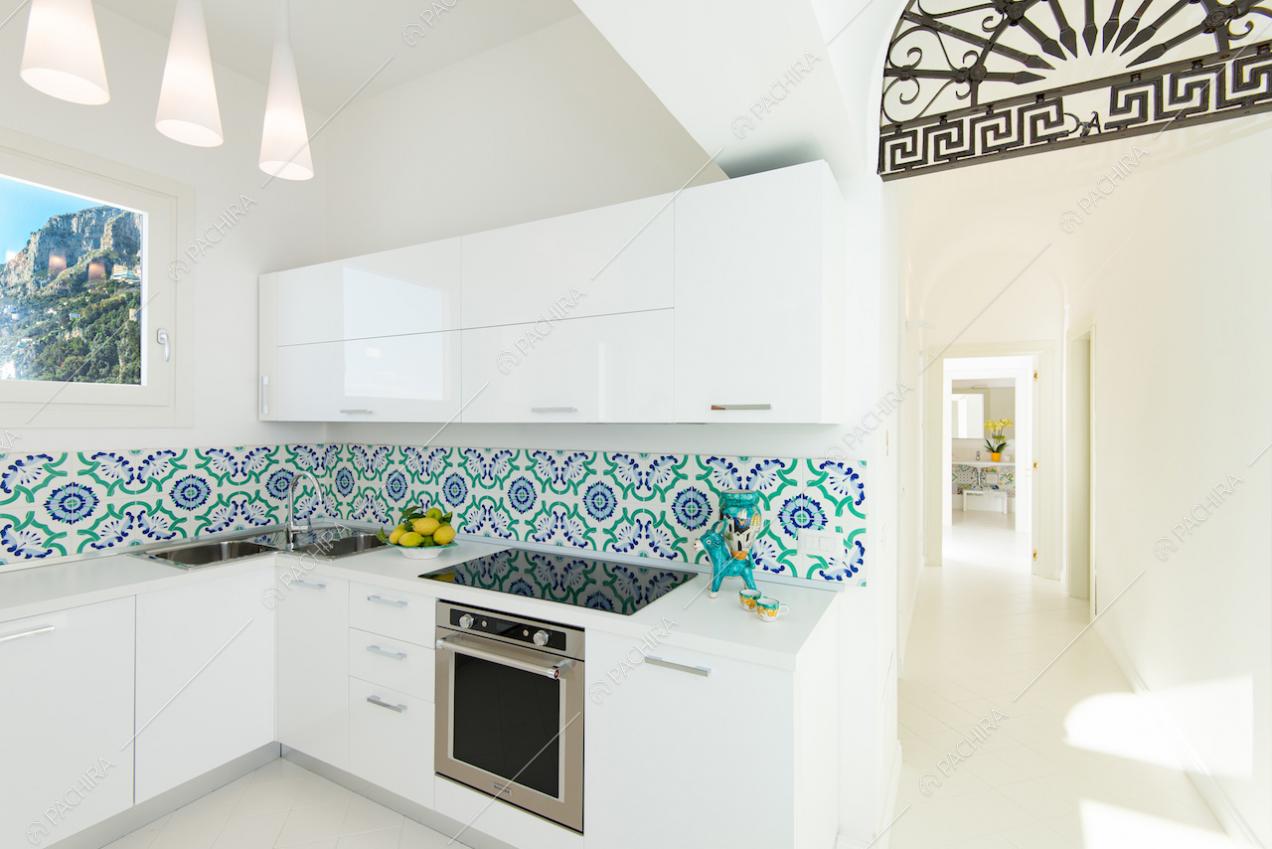 Cucina a parete bianca con piastrelle decorative sulla parete