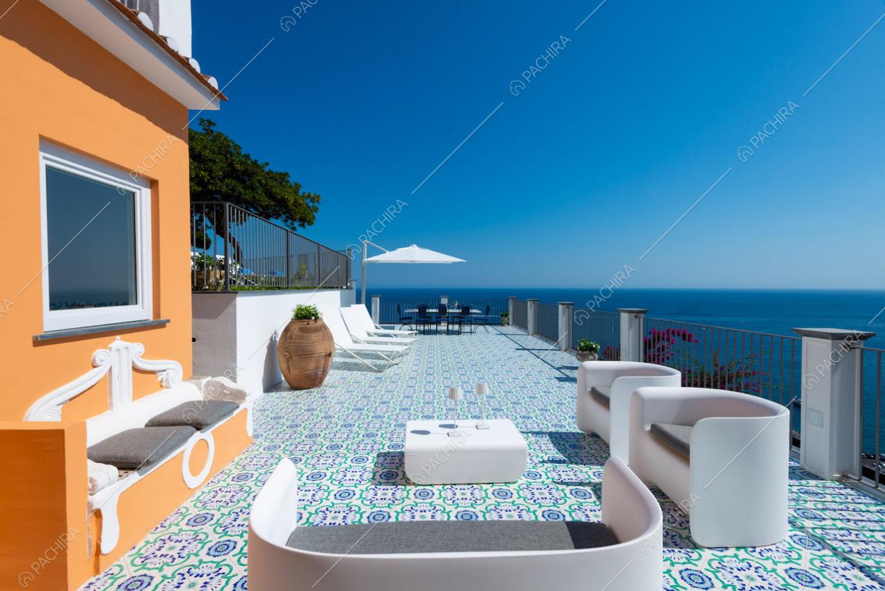 Terrazza a strapiombo sul mare con sedie e divanetti
