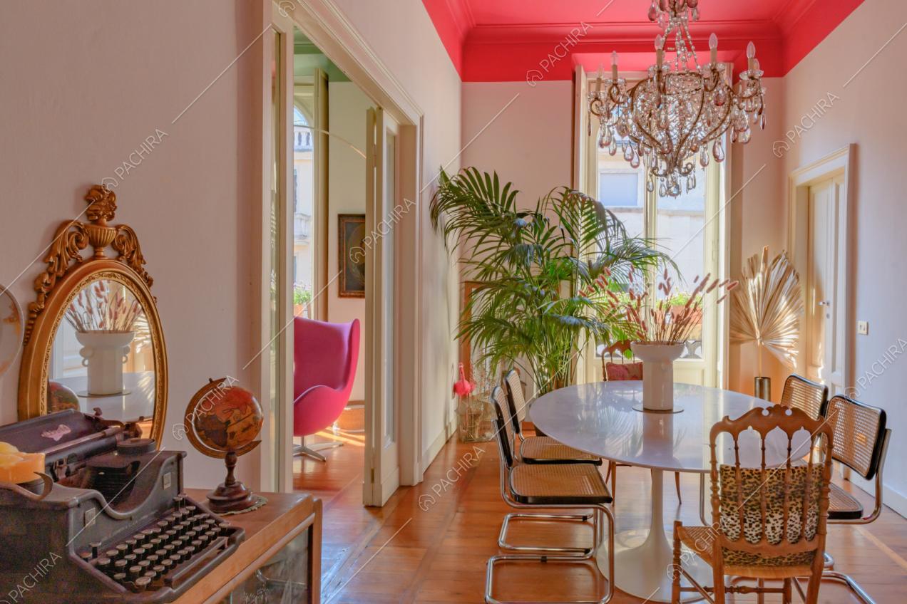 Sala da pranzo dal soffitto fucsia con boiserie, pareti bianche e tavolo bianco