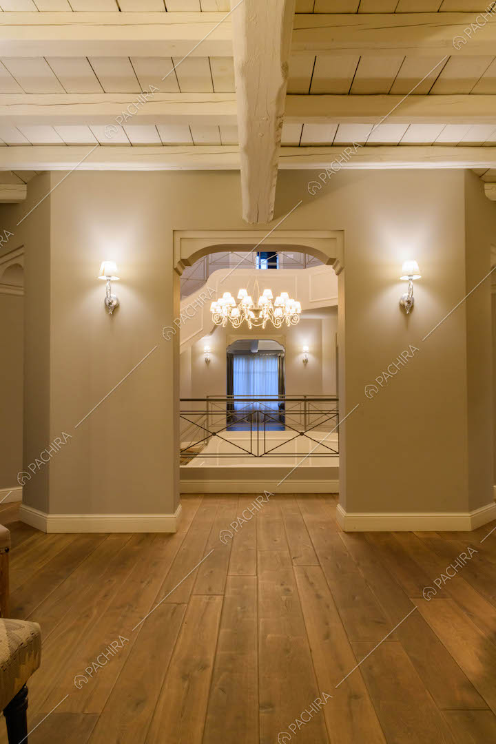 Pareti grigie e pavimento in parquet nella sala che si affaccia sulle scale