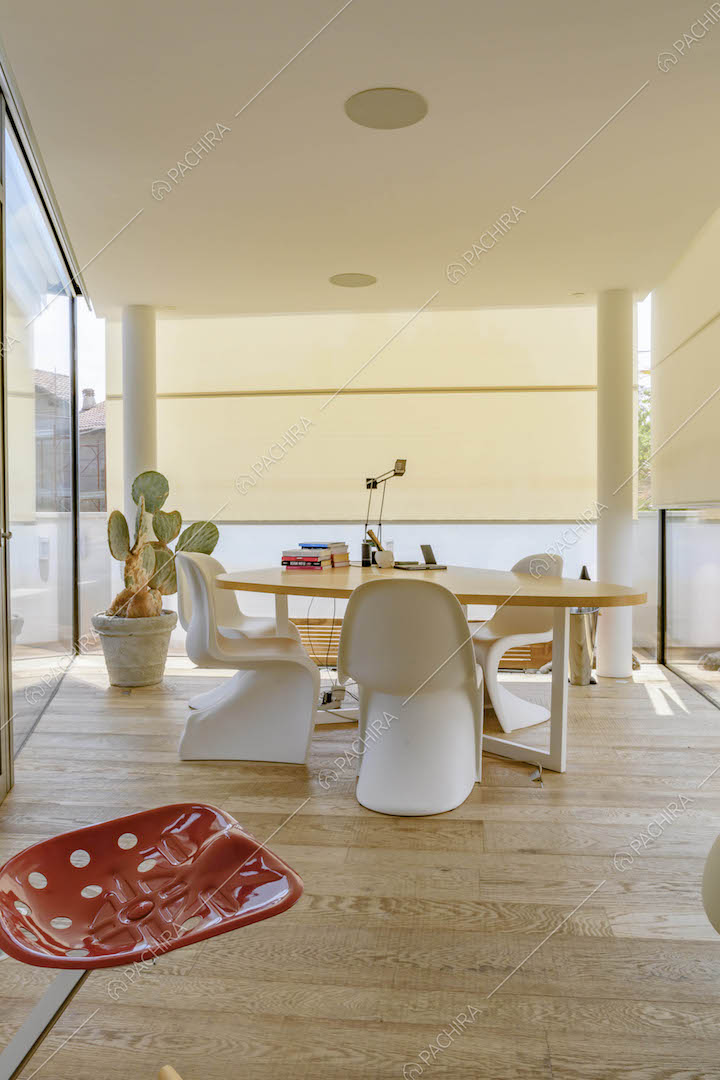 Veranda con pavimento in parquet, tavolo da pranzo e sedie di design