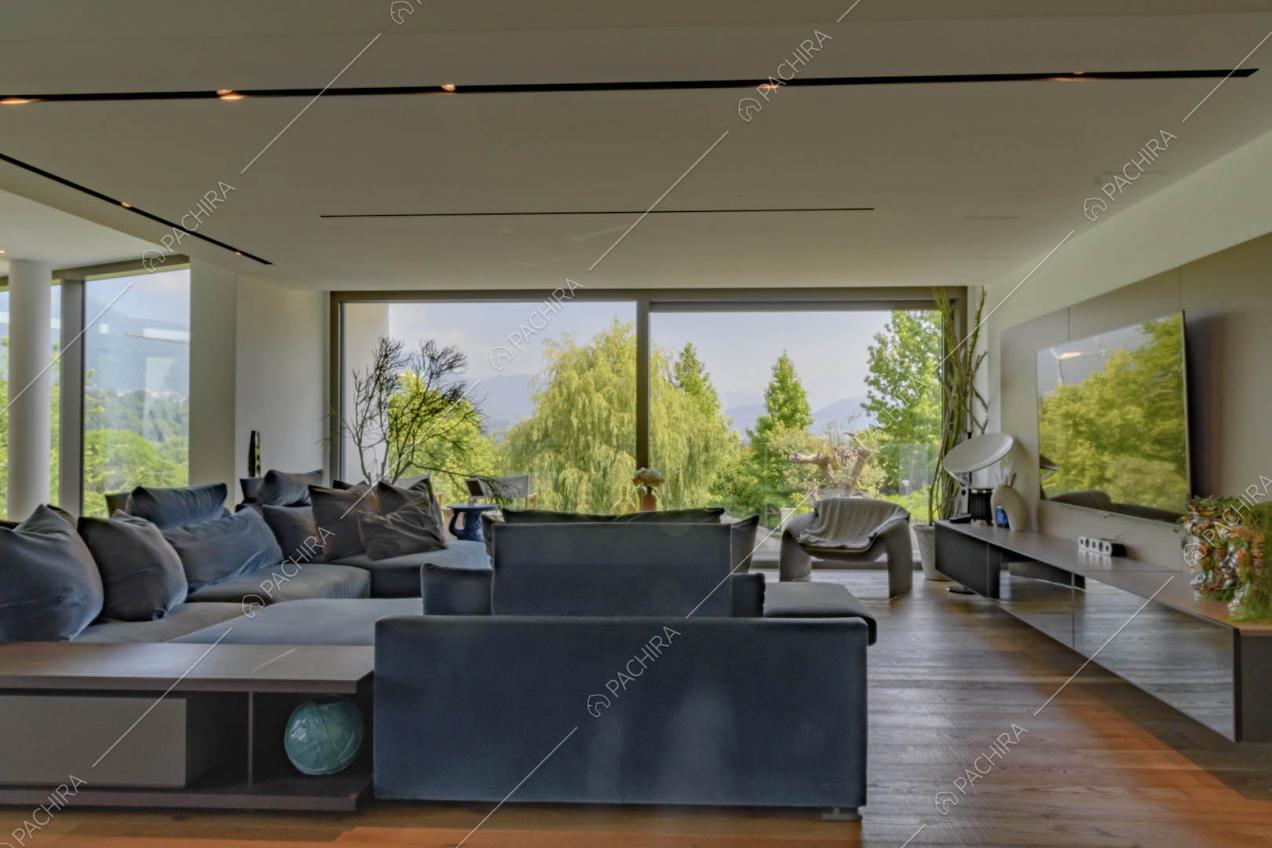 Divani blu nella grande sala con pavimento in parquet e vetrate
