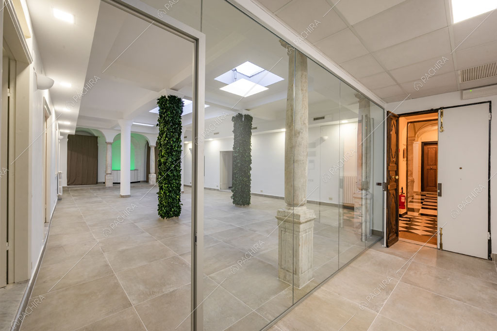 Ampio salone con lucernari, colonne, vetrate e vista sul grande atrio