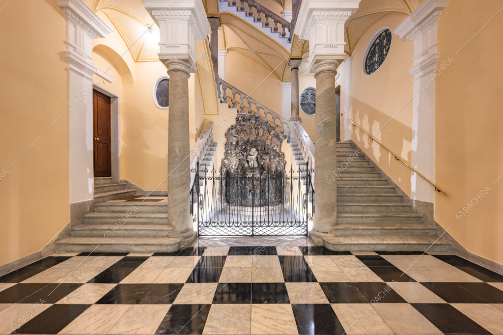 Atrio monumentale della location con pavimento in marmo a scacchi, scale e colonne