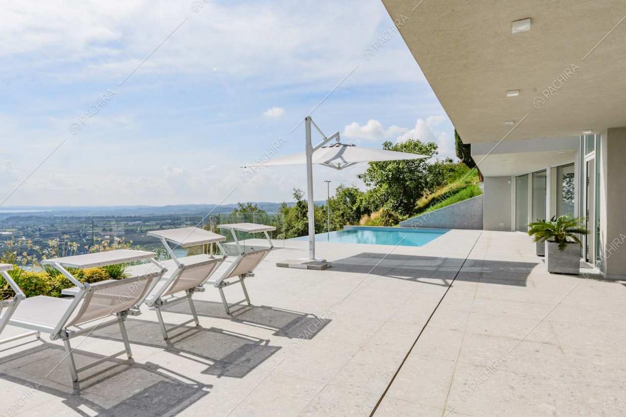 Grande terrazza con lettini, piscina e vista sul lago