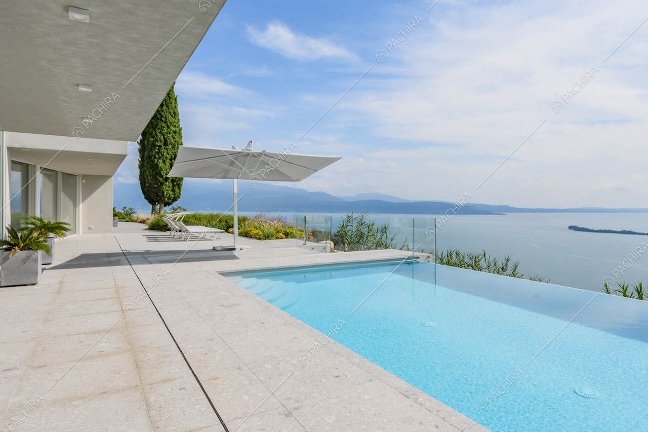 Grande terrazza con piscina a sfioro e vista sul lago
