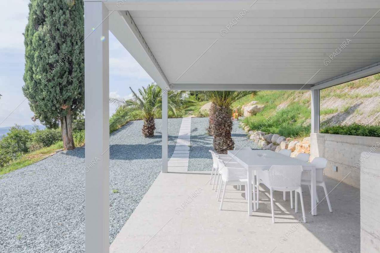 Grande patio con tavolo da pranzo bianco e vista sul lago