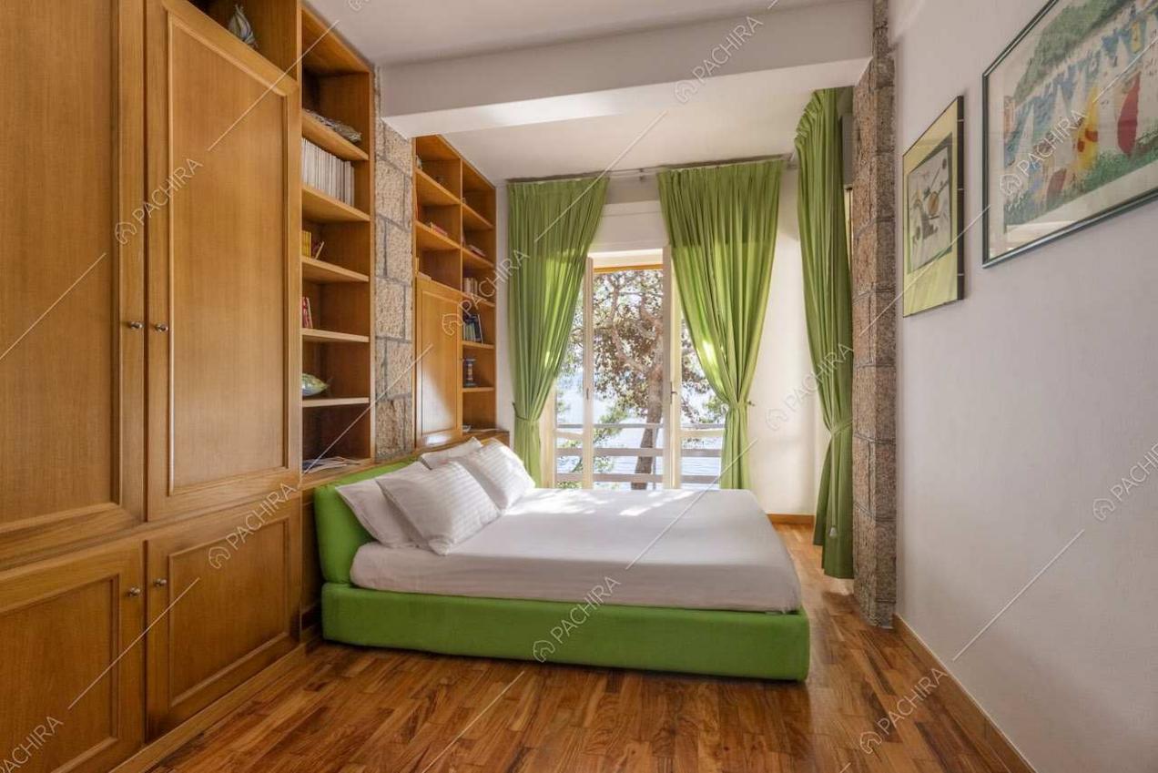 Camera da letto matrimoniale con pavimento in parquet e colonne in pietra