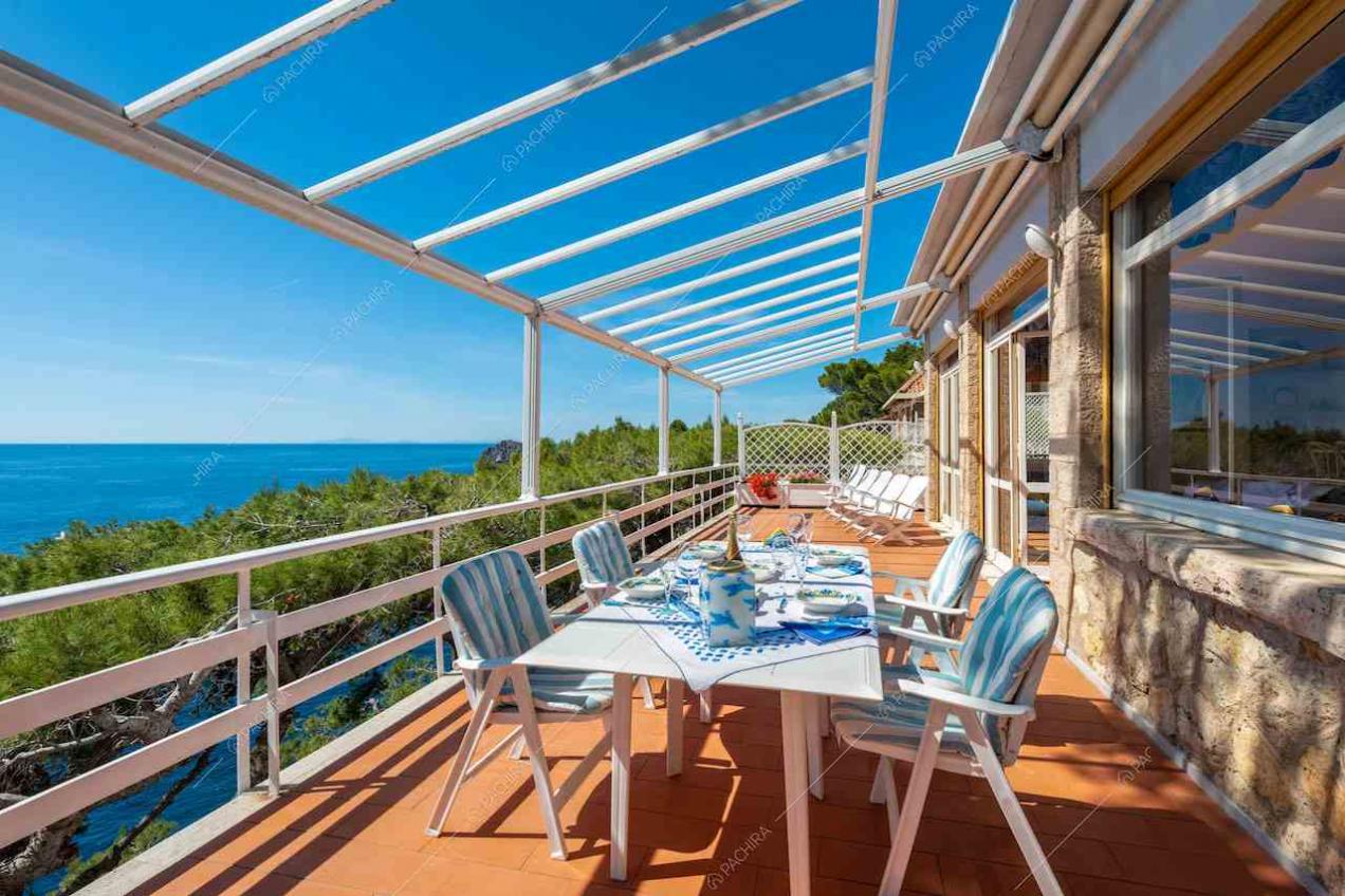 Grande terrazza con tavolo da pranzo bianco e vista sul mare
