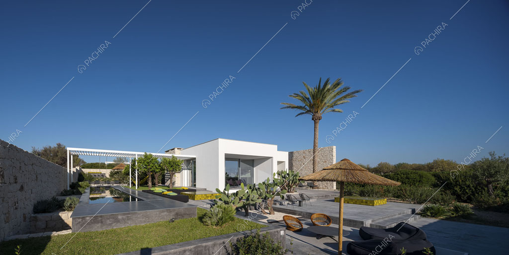 Vista sul grande giardino della location con esterni bianchi, piscina e patio