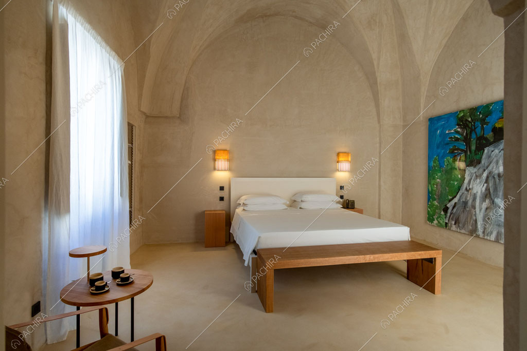 Panca in legno nella camera da letto con quadro, vetrata e volte sul soffitto