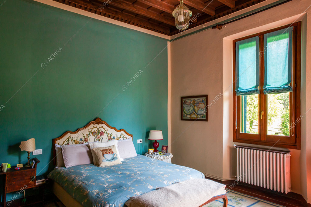 Camera da letto matrimoniale con parete azzurra e soffitto a cassettoni
