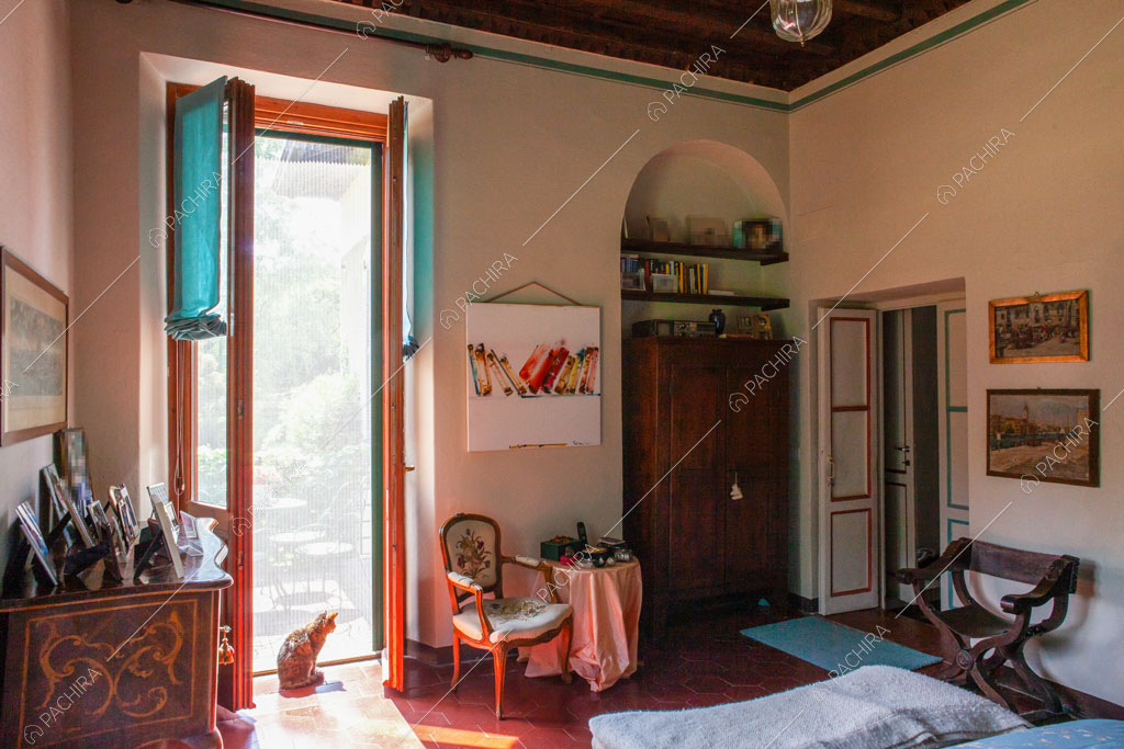 Camera da letto con porta-finestra, pavimento in cementine e boiserie sulla porta