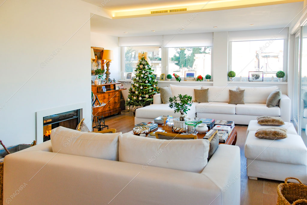 Luminosa zona living con divani bianchi, pavimento in parquet e camino