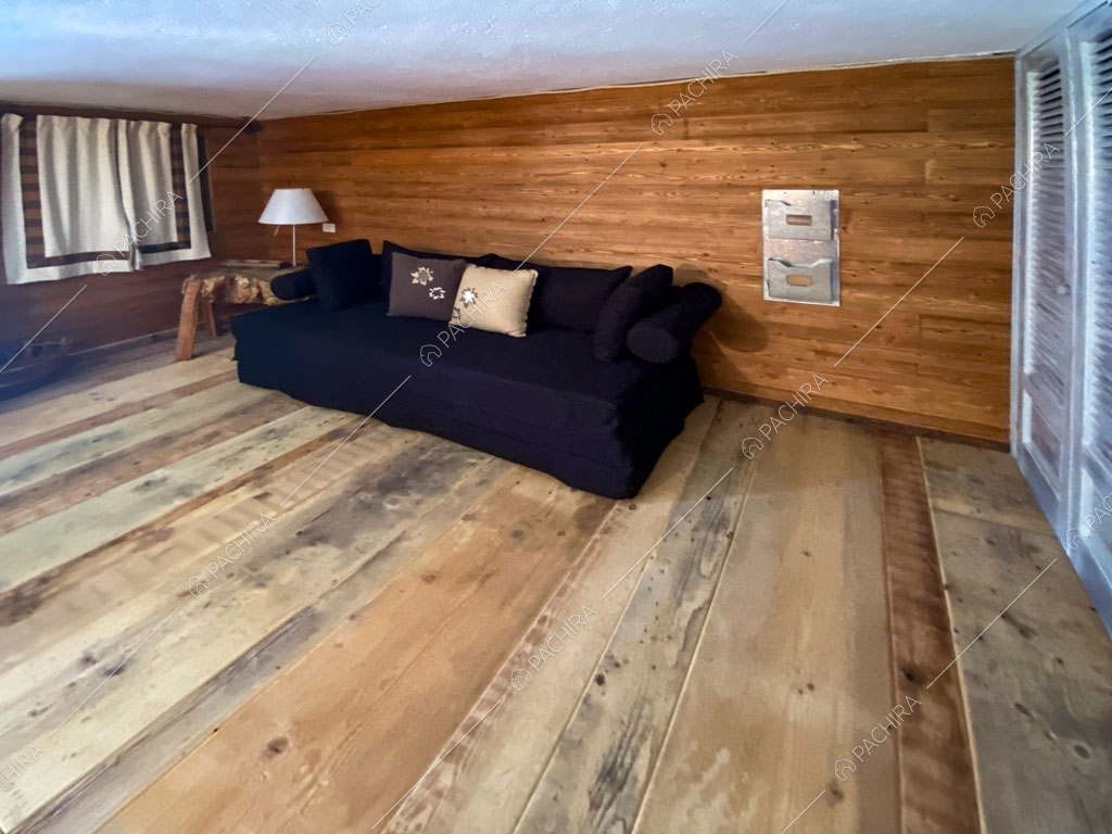 Divano nero nella sala dello chalet Thar, location in stile rustico ad Aosta