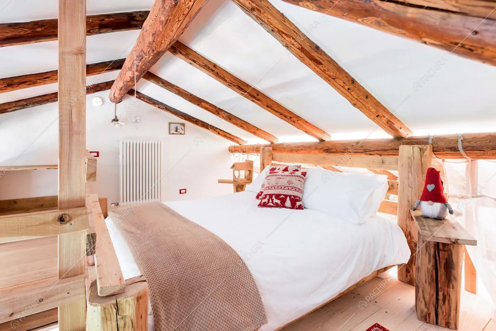 Camera da letto matrimoniale con pavimento in parquet dello chalet Cantabrico, location in stile rustico a Trento