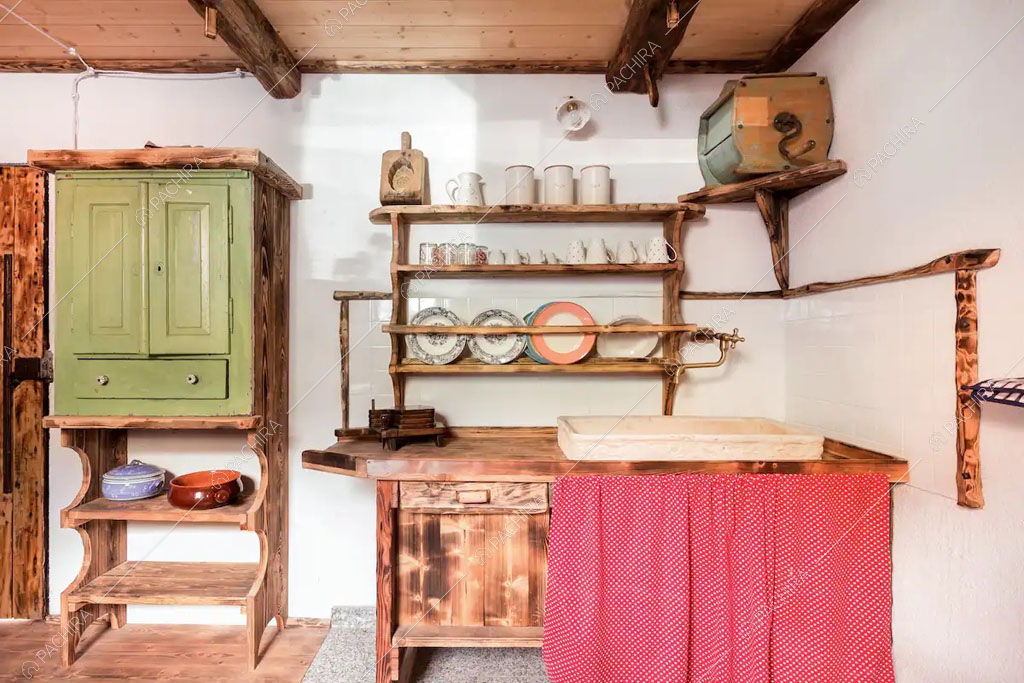 Travi in legno a vista sul soffitto della cucina dello chalet Cantabrico, location in stile rustico a Trento