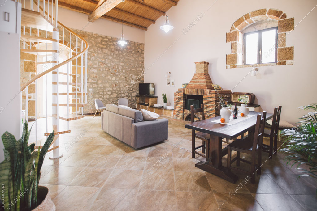 Sala con travi in legno a vista sul soffitto della villa Hibiki, location in stile moderno a Siracusa