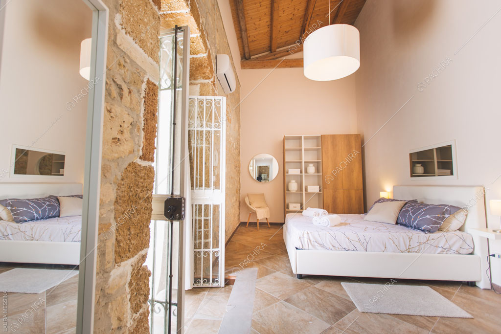 Travi in legno a vista sul soffitto della camera della villa Hibiki, location in stile moderno a Siracusa