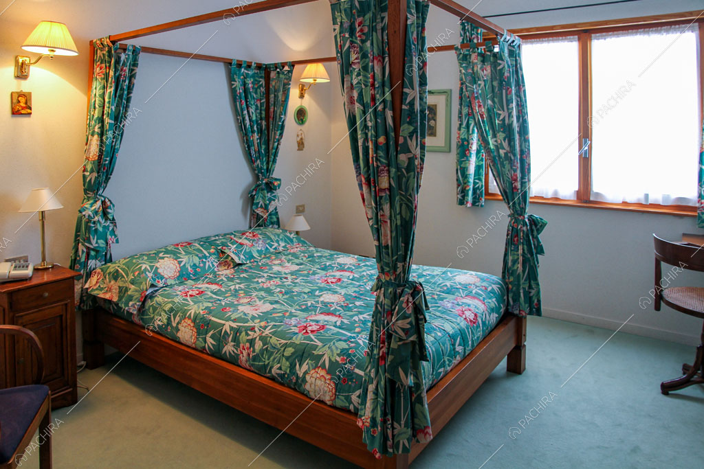Letto a baldacchino nella camera dello chalet Betel, location in stile rustico a Lecco