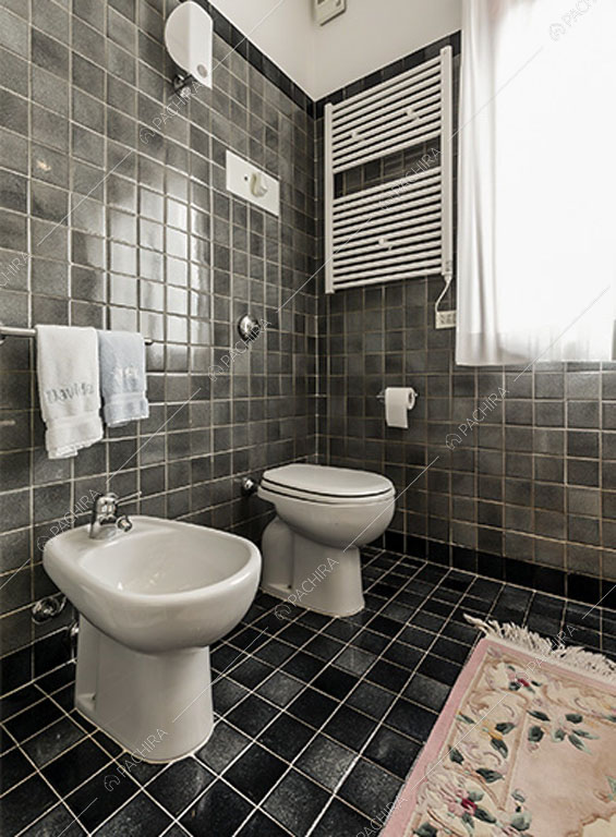 Piastrelle nere su pavimento e pareti del bagno dello chalet Betel, location in stile rustico a Lecco