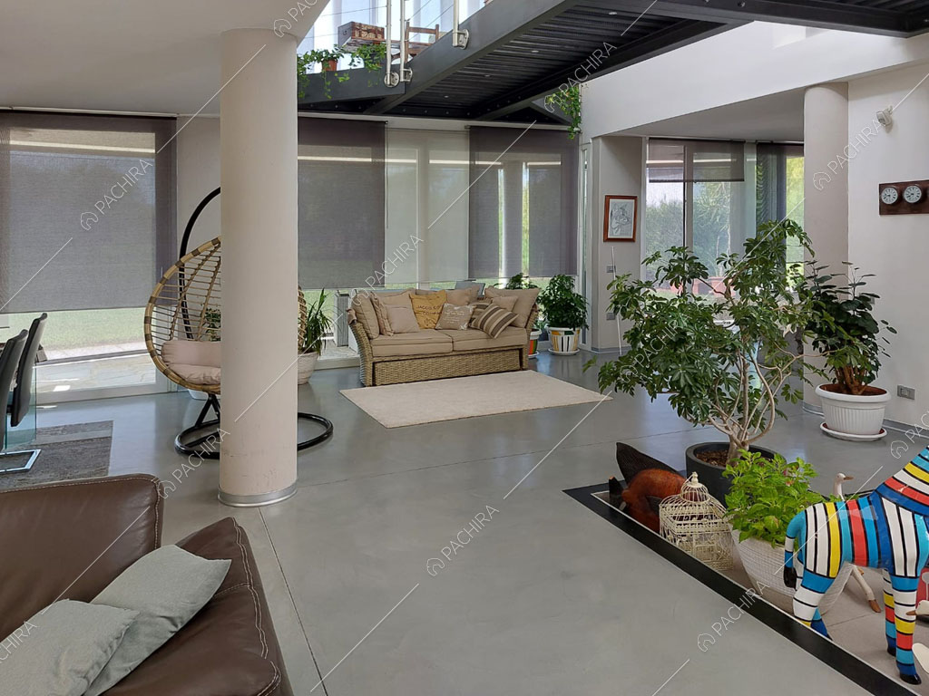 Pavimento in cemento lisciato nella zona living della villa Luzon, location in stile moderno a Padova