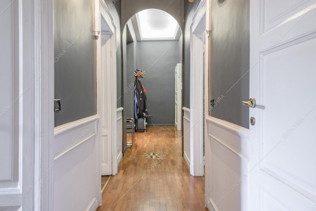 Arco nel lungo corridoio con pavimento in parquet