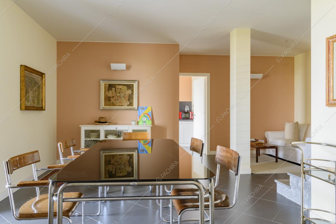 Tavolo da pranzo di design collocato in sala dalle pareti gialle e arancioni