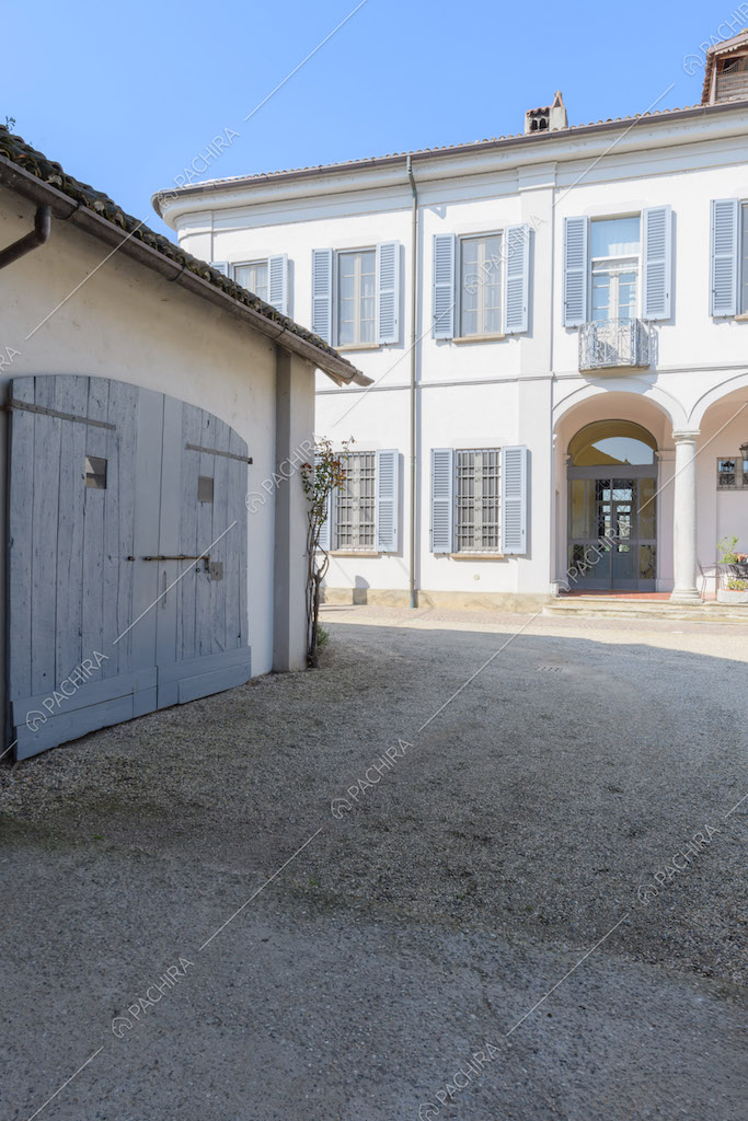 Pavimentazione in ciottoli nel cortile con vista sugli esterni bianchi della location