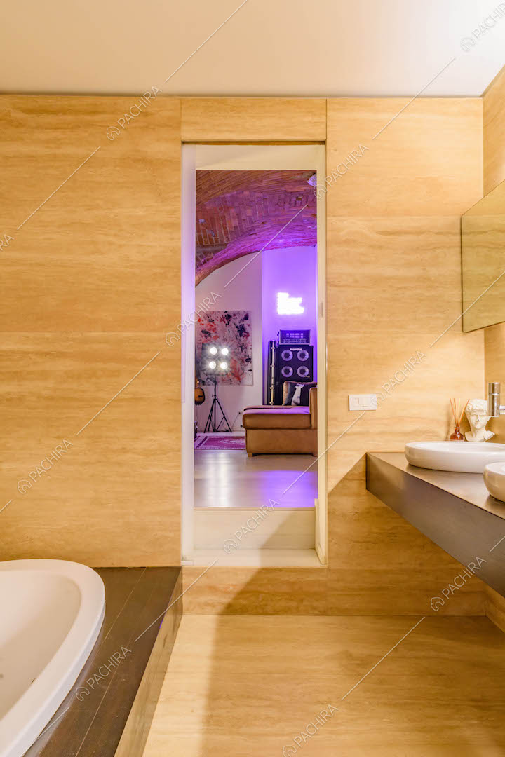 Dal bagno con pavimento e pareti in parquet vista sul salotto