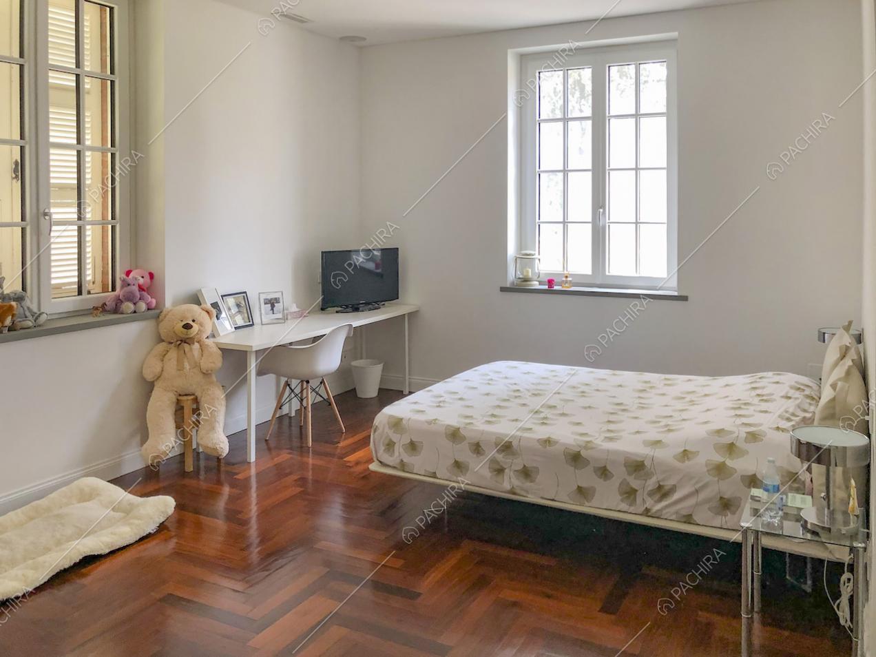 Camera da letto con pavimento in parquet e scrivania
