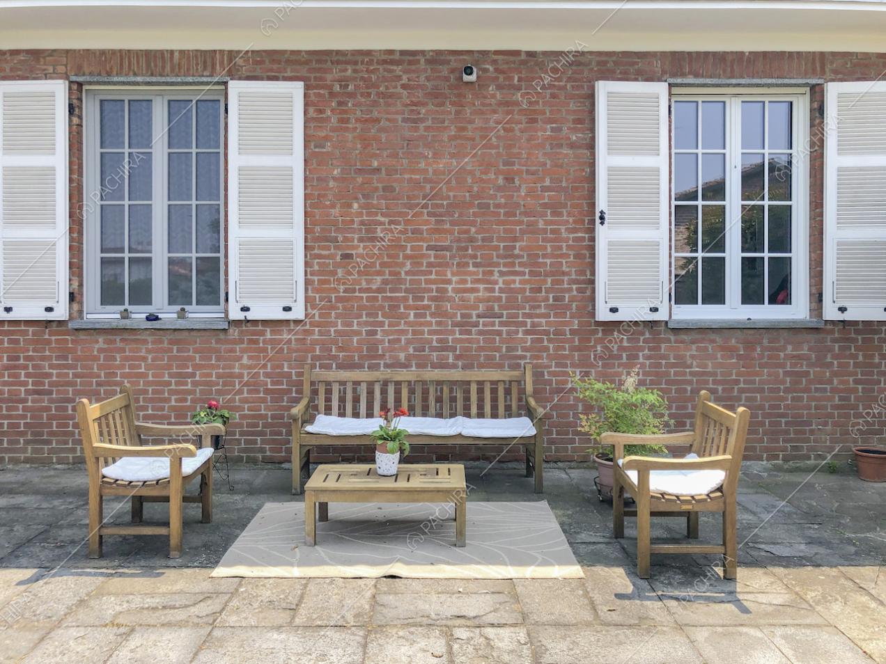 Panchine e tavolino in legno nel patio della villa